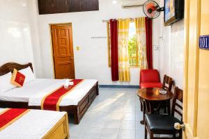 a hotel room with two beds and a table at Hồng Phát 68 Hotel in Ho Chi Minh City +9 photos
