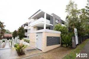a building with a garage in front of it at KozyGuru | Epping | Stylish 1 Bedroom Apartment in Epping