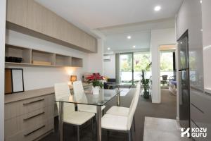 a kitchen and dining room with a glass table and chairs at KozyGuru | Epping | Stylish 1 Bedroom Apartment in Epping