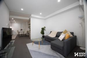 a living room with a couch and a tv at KozyGuru | Epping | Stylish 1 Bedroom Apartment in Epping