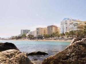 Blick auf einen Strand mit einigen Felsen und Gebäuden in der Unterkunft Ona Princesa Playa in Marbella