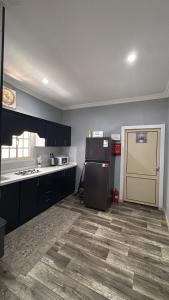 a kitchen with a black refrigerator and a door at شقة وقف الخير اسبوعي وشهري Charity apartment, weekly and monthly in Medina