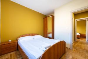 a bedroom with a bed and a yellow wall at Apartments Bečić in Budva
