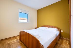 a bedroom with a large bed with a yellow wall at Apartments Bečić in Budva