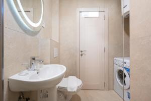 a bathroom with a sink and a washing machine at Apartments Bečić in Budva
