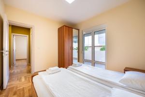 two beds in a room with a large window at Apartments Bečić in Budva +55 photos