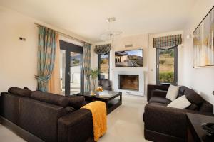 a living room with two couches and a fireplace at Lamon Villa in Plakias