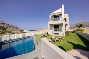 a villa with a swimming pool and a house at Lamon Villa in Plakias