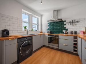 a kitchen with a washer and dryer in it at Holiday Home Sullivan by Interhome in Drumnadrochit