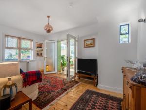 a living room with a couch and a tv at Holiday Home Sullivan by Interhome in Drumnadrochit