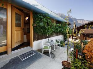 a patio with a table and chairs outside of a building at Apartment Beim Thor Klein by Interhome in Brienzwiler
