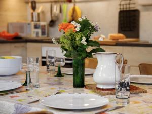 a table with plates and a vase with flowers on it at Apartment Beim Thor Klein by Interhome in Brienzwiler