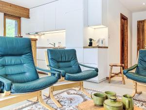a living room with two chairs and a kitchen at Apartment Le Sporting 213 by Interhome in Champex