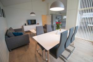 a dining room with a white table and chairs at Lofthus Camping in Lofthus