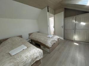 a small bedroom with two beds and a cabinet at Maison indépendante Anna in Wittenheim +1 photo