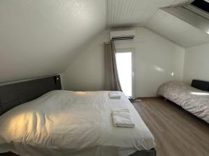 a bedroom with a white bed and a window at Maison indépendante Anna in Wittenheim