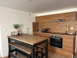 a kitchen with wooden cabinets and a wooden table and a counter at Maison indépendante Anna in Wittenheim