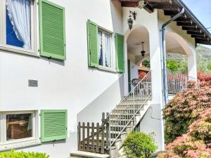 a house with green shutters and stairs at Apartment Roberto by Interhome in Mergozzo