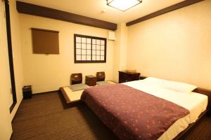 a hotel room with a bed and two chairs at K's House Tokyo Oasis - Quality Hostel in Asakusa in Tokyo