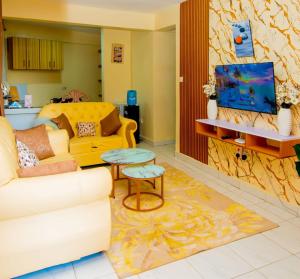 a living room with a couch and a tv at JVV Bright Suites BnB in Eldoret