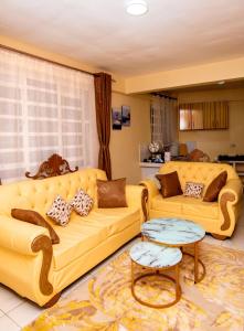 a living room with two yellow couches and a table at JVV Bright Suites BnB in Eldoret