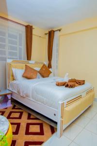 a bedroom with a large bed with brown pillows at JVV Bright Suites BnB in Eldoret