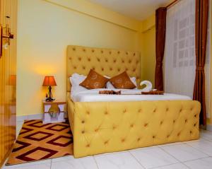 a yellow bed with a yellow headboard in a bedroom at JVV Bright Suites BnB in Eldoret