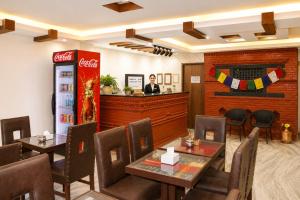 a man standing at the counter of a restaurant with a soda machine at Apartment Hotel 11 Thamel in Kathmandu