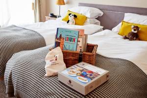 a bed with a basket of books and a stuffed dog at 9 Hertford Street Mayfair in London +6 photos