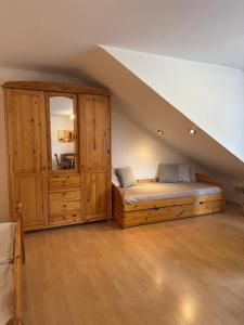 a bedroom with a bed and a large wooden cabinet at Pension & Ferienhof Glüß in Lünzen