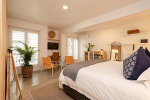 ein Schlafzimmer mit einem Bett und einem Schreibtisch und einem Zimmer in der Unterkunft Eleven in Plettenberg Bay