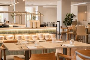a dining room with tables and chairs at AR Roca Esmeralda & SPA Hotel in Calpe
