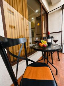 a table with a bowl of fruit and wine glasses at Historic Centre Apartment Kutaisi in Kutaisi