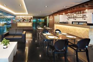 um restaurante com mesas e cadeiras e um bar em Diamond Residence Ratchada em Bangkok