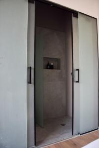 an open glass door in a room with a bathroom at L7 Urban Studios in Tel Aviv