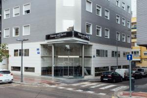 a building on a street with cars parked in front of it at Hotel Malcom and Barret in Valencia