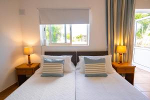 a bedroom with a large white bed with two lamps at Centre Algarve in Moncarapacho +60 photos