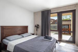 a bedroom with a large bed and a balcony at Kredo in Solotvyno