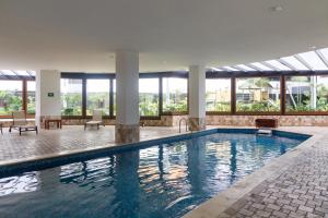 a large swimming pool in a building with windows at Suites Metropoli Bristol Parc in Quito