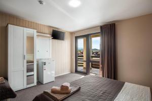 a bedroom with a bed and a refrigerator and a window at Kredo in Solotvyno +13 photos