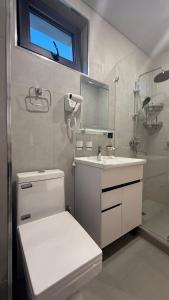 a bathroom with a toilet and a sink and a mirror at Maskan Premium Hotel Tashkent in Aktepa-Chigatay