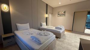 a hotel room with two beds and a window at Maskan Premium Hotel Tashkent in Aktepa-Chigatay