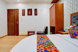 a bedroom with a bed with a colorful blanket on it at FabHotel SV Grand I in Varanasi +37 photos