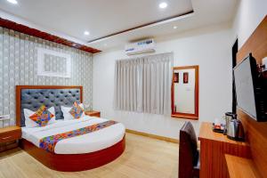 a bedroom with a bed and a flat screen tv at FabHotel SV Grand I in Varanasi