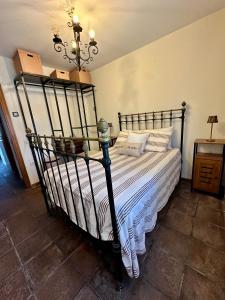 a bedroom with a black bed with white sheets at Finca Viña Alberto in Cuéllar +5 photos