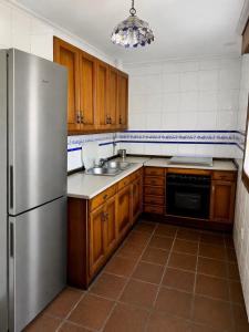 a kitchen with wooden cabinets and a stainless steel refrigerator at Finca Viña Alberto in Cuéllar
