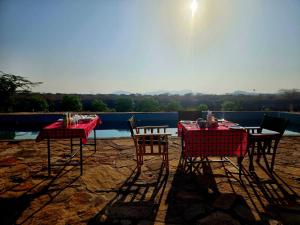 two tables and chairs sitting on a patio at Samburu Tempo Camp in Archers Post