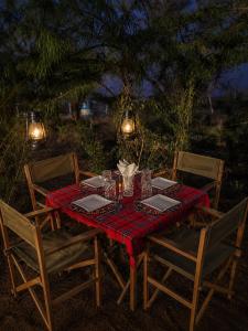 a table with a red table cloth on it with chairs at Samburu Tempo Camp in Archers Post