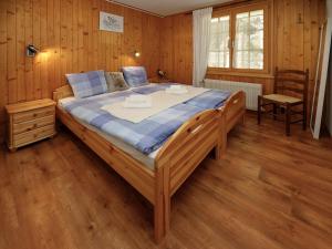 a large bed in a room with wooden walls at Apartment Chalet l'Aube by Interhome in Vers L'Eglise