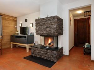 a living room with a stone fireplace with a tv at Apartment Chalet l'Aube by Interhome in Vers L'Eglise